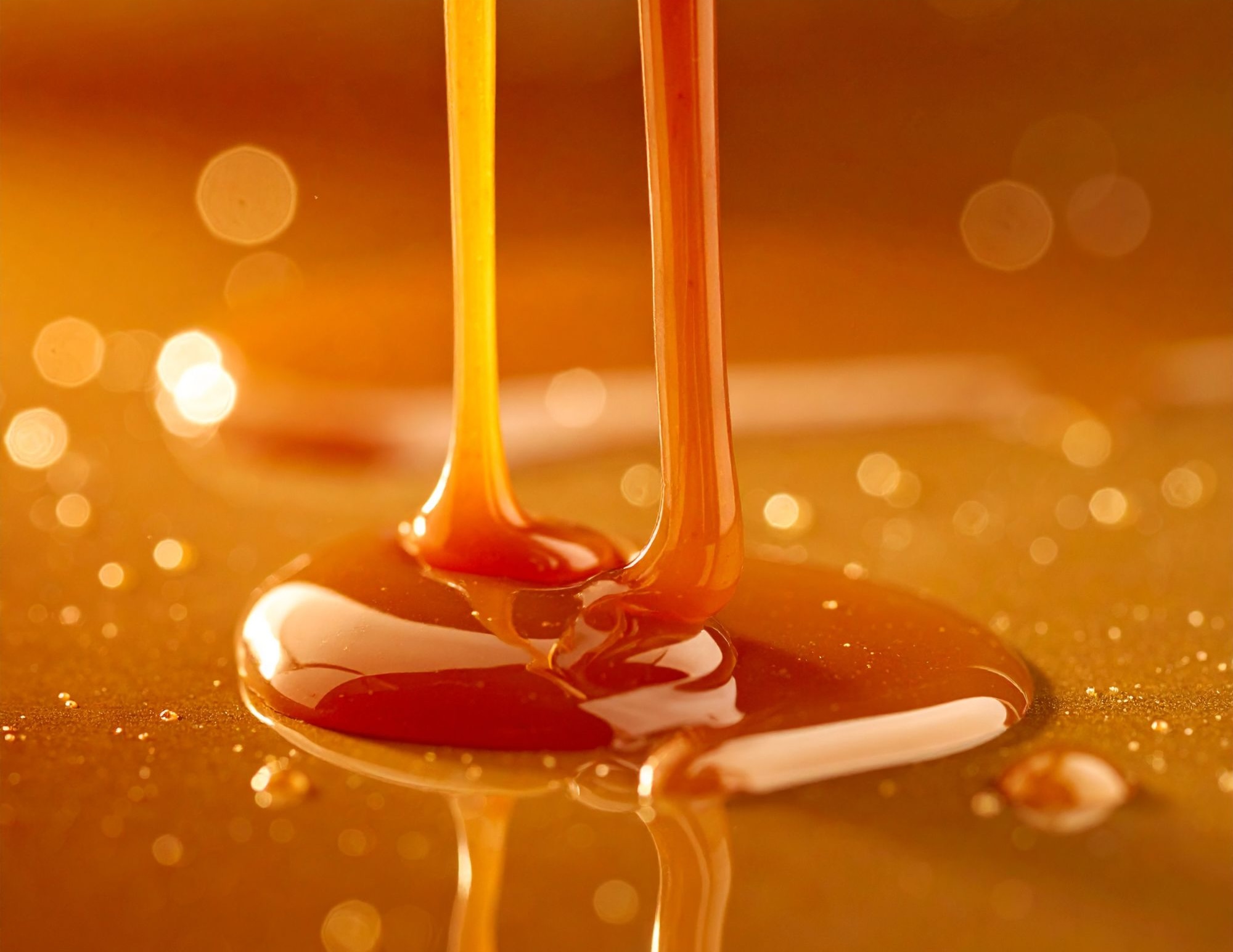 Caramel pouring in glossy amber streams